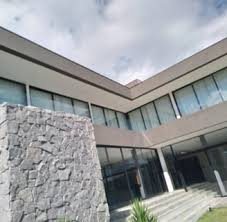 Fachada com parede de pedra e esquadrias de vidro