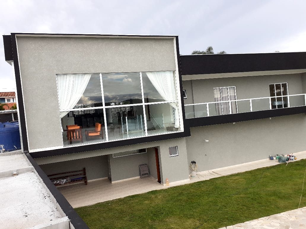 Casa com pintura cinza e detalhes pretos na fachada