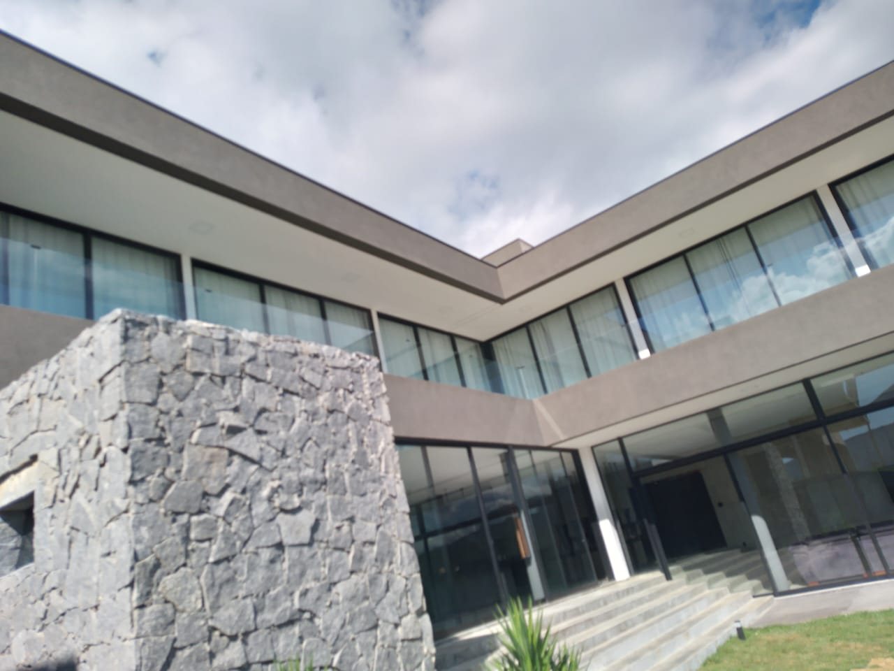 Fachada com painel de pedra e pintura em tom areia